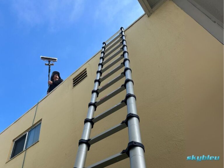 Skybleu technician cleaning windows on a high building with professional equipment in the San Francisco Bay Area.